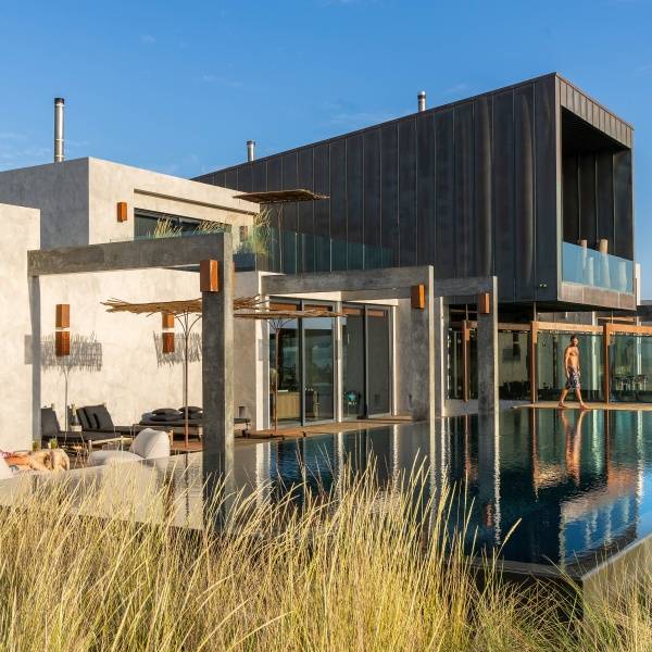 Luxurious room at Areias do Seixo Hotel with a stunning view of the dunes and sea, featuring elegant decor, a fireplace, and a decked terrace.